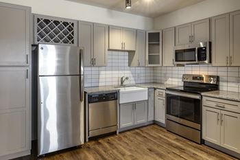 a kitchen with white cabinets and stainless steel appliances